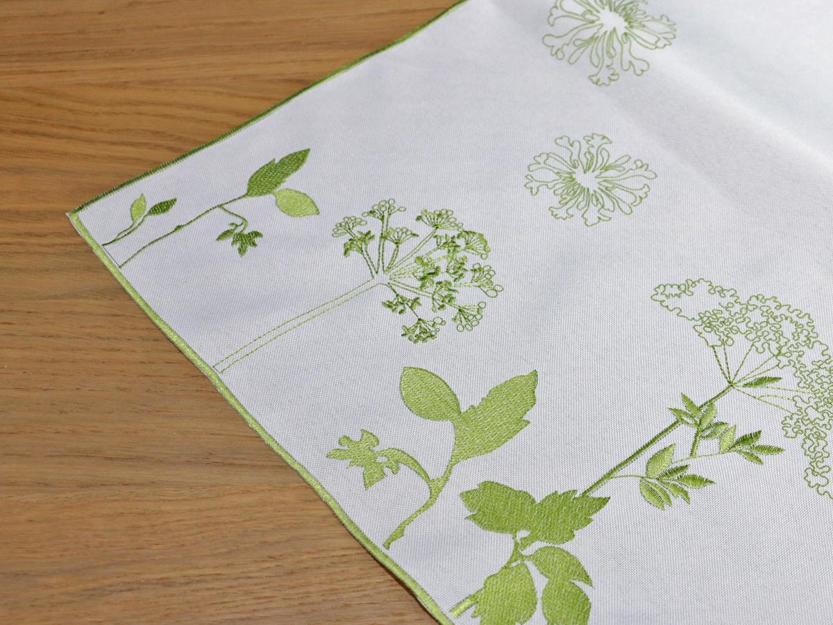 white table runner with green floral embroidery