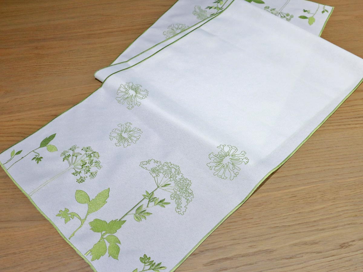white table runner with green floral embroidery